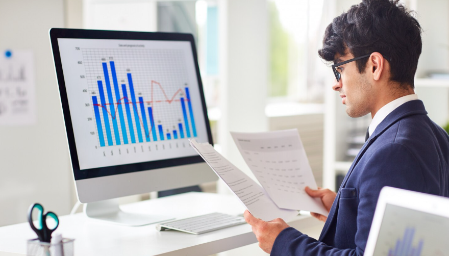 Analyst reviewing a bar chart on a desktop monitor